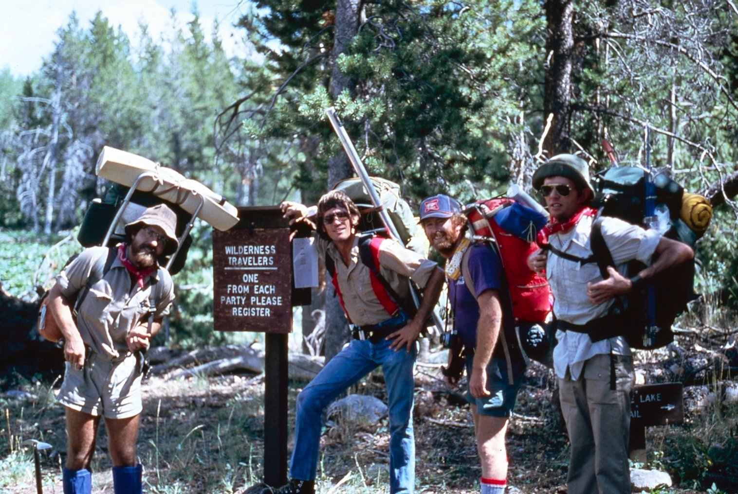 Four Men circa 1970's wearing large oversized backpacks in the wilderness. 